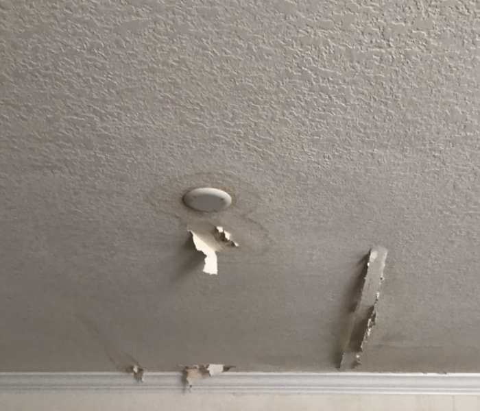 a ceiling with discoloration around a light fixture